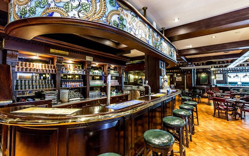 Bar area inside Tiger Brewery, Singapore, featuring beer taps and seating.