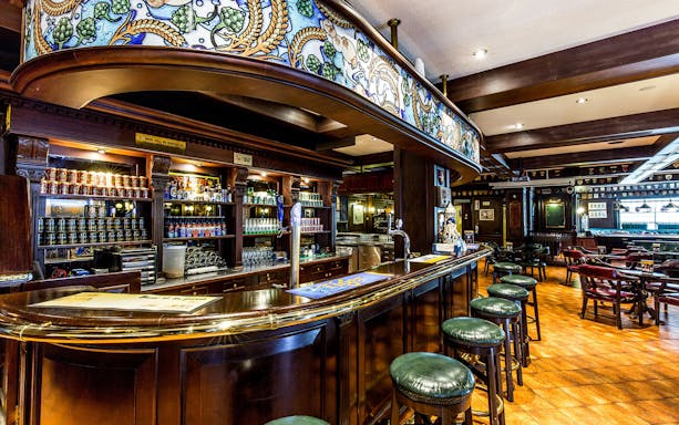 Bar area inside Tiger Brewery, Singapore, featuring beer taps and seating.
