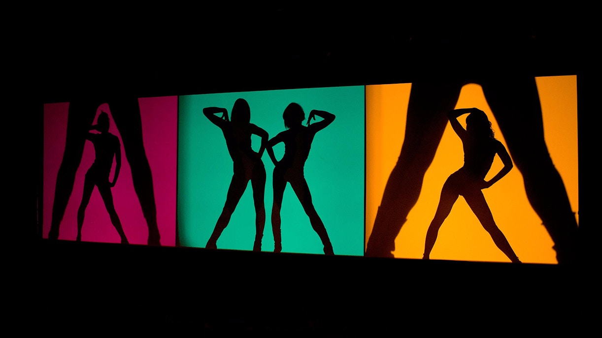 Dançarinas do cabaré Crazy Horse em Paris, em performance coreografada com iluminação artística.