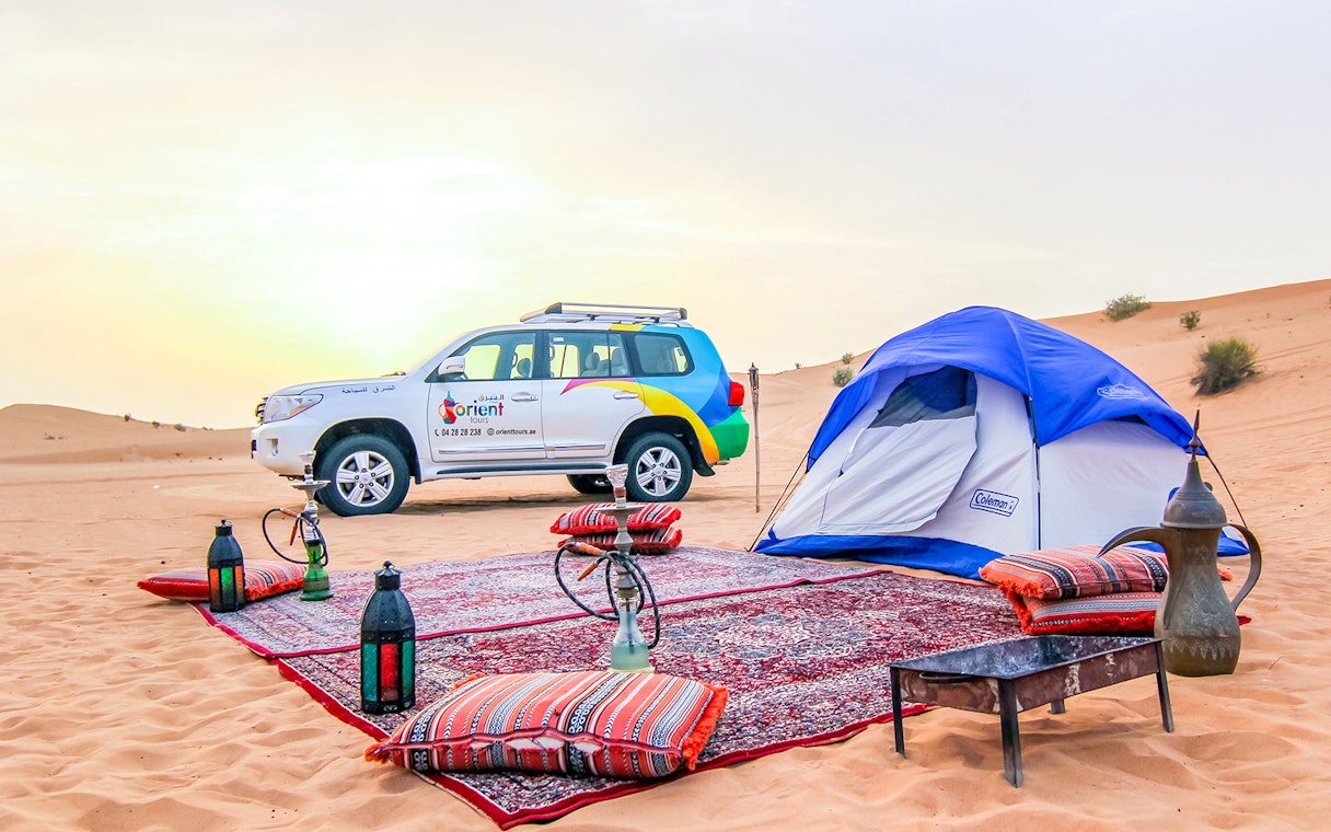 Desert campsite with tent, 4x4 vehicle, and traditional setup for Morning Desert Safari.