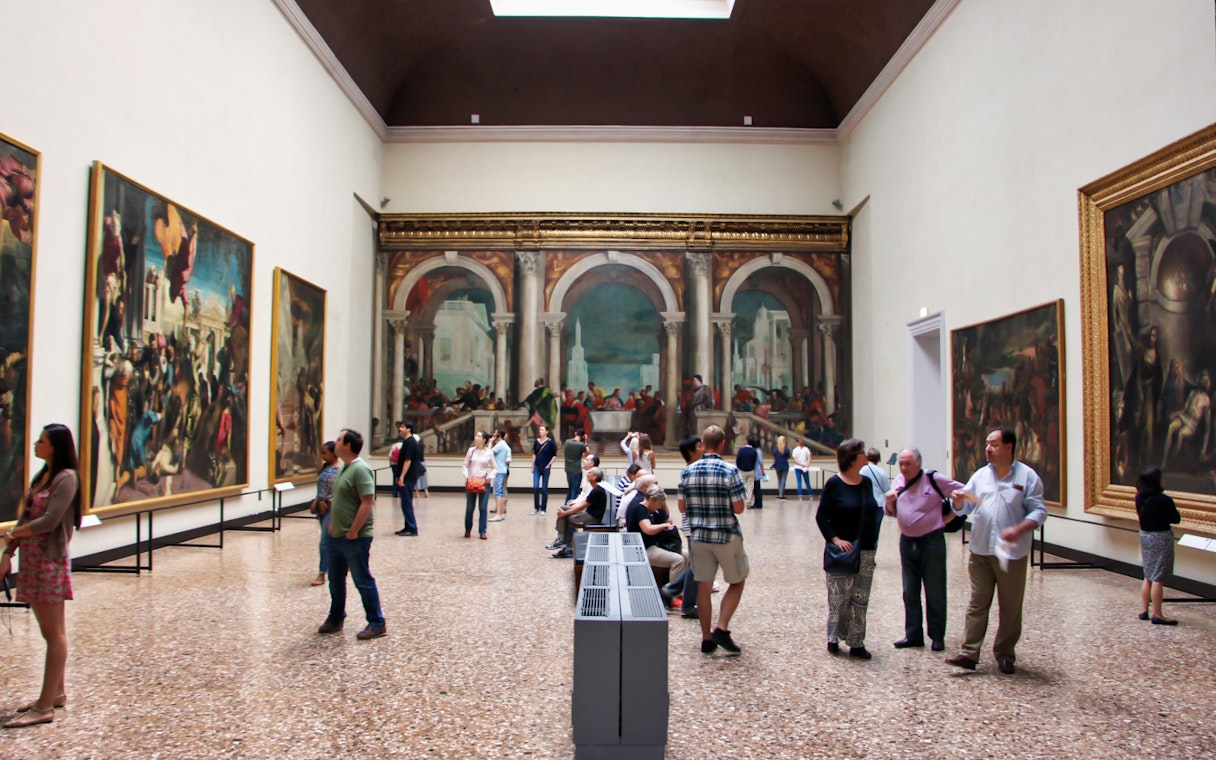 Visitors viewing Renaissance paintings in a gallery at the Accademia, Florence.