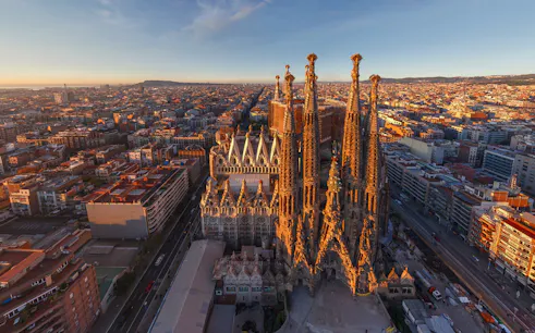 Aerial view of Sagrada Familia in Barcelona at sunset, highlighting its intricate towers.