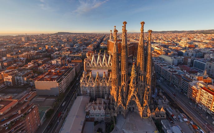 Aerial view of Sagrada Familia in Barcelona at sunset, highlighting its intricate towers.