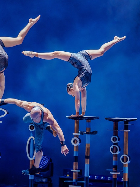 Acrobats performing handstands on elevated platforms at La Perle by Dragone show.