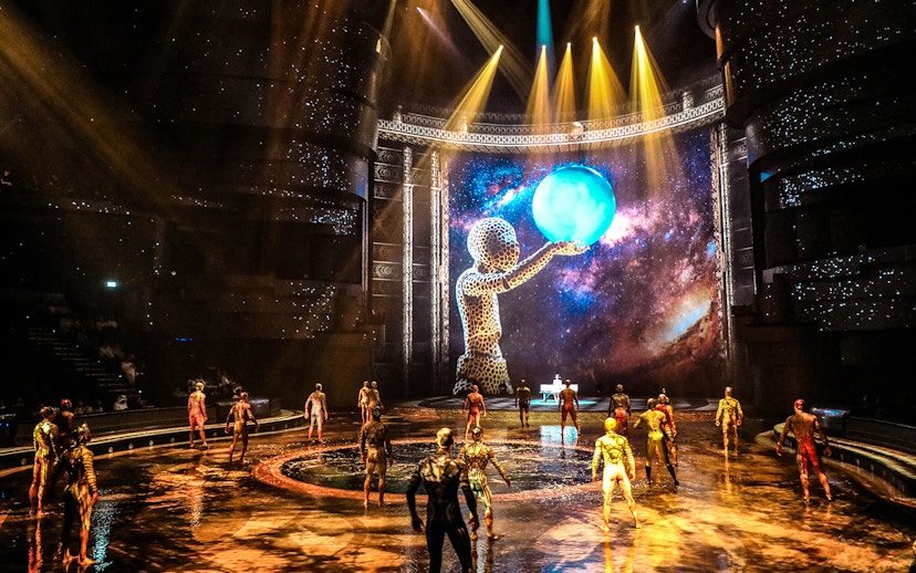 Performers on stage at La Perle by Dragone, Dubai, with a cosmic backdrop.