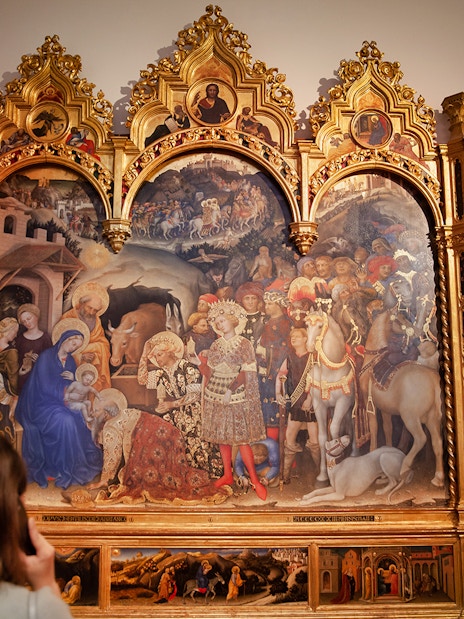 Visitor admiring a Renaissance painting at the Uffizi Gallery in Florence.