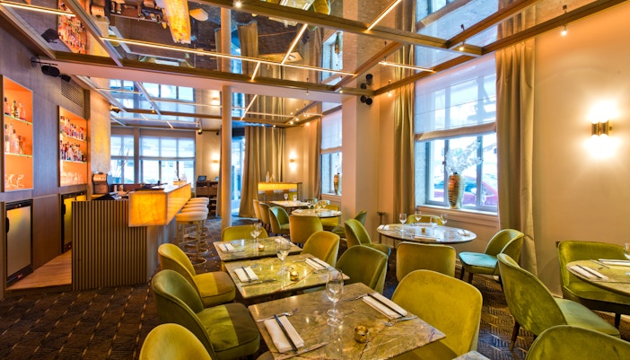 Ambiente luxuoso de cabaré em Paris, com mesas elegantemente arrumadas e iluminação suave.