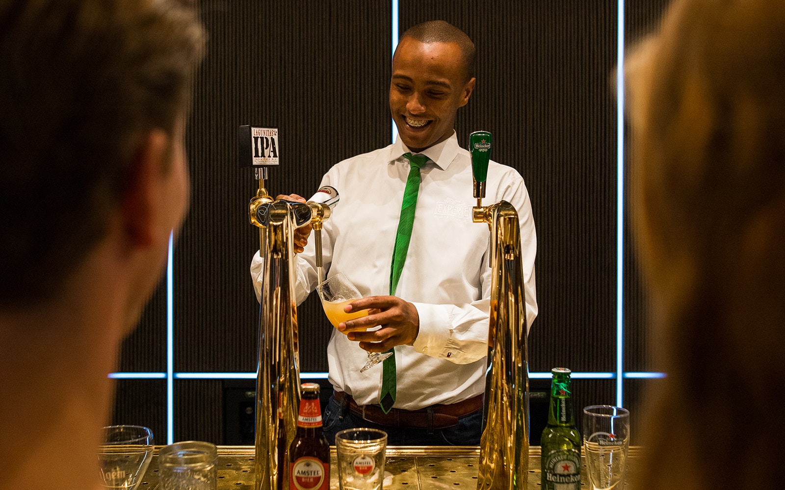 Bartender pouring beer at Heineken® Experience in Amsterdam.