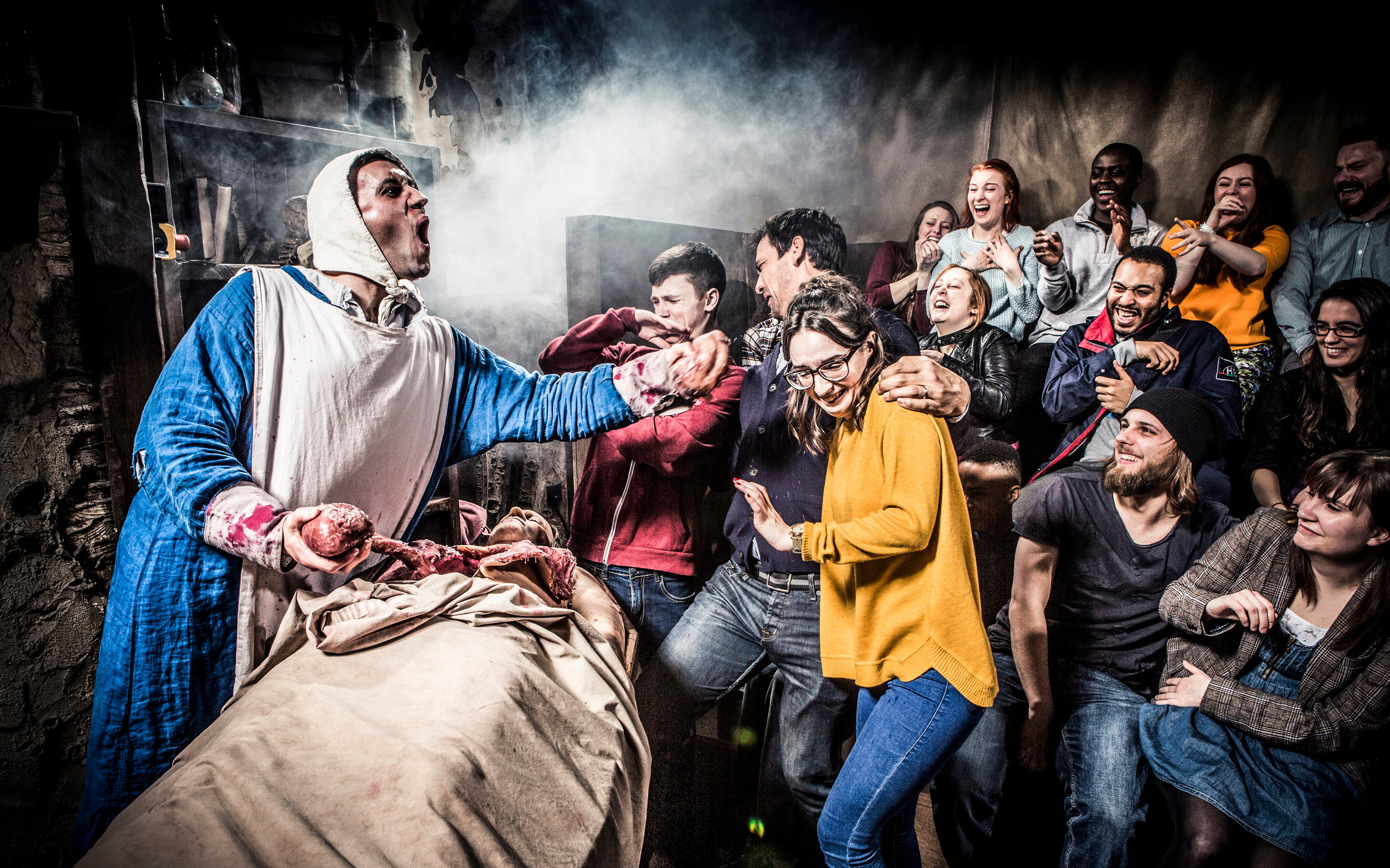 Visitors react to a theatrical performance at Amsterdam Dungeon during a sightseeing bus tour.