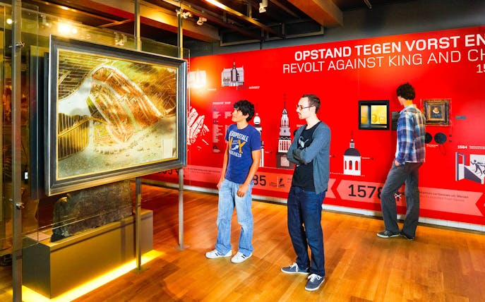 Visitors viewing historical exhibits at Amsterdam Museum.