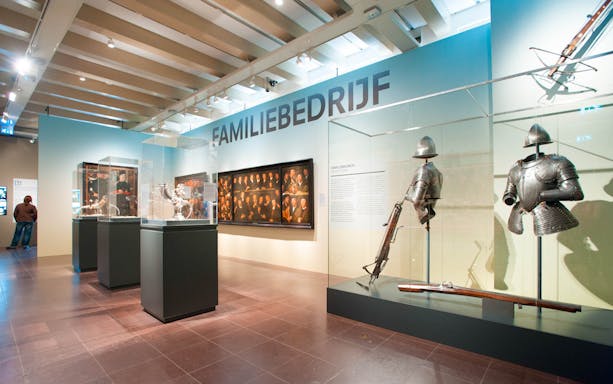 Amsterdam Museum exhibit with armor and family portraits.