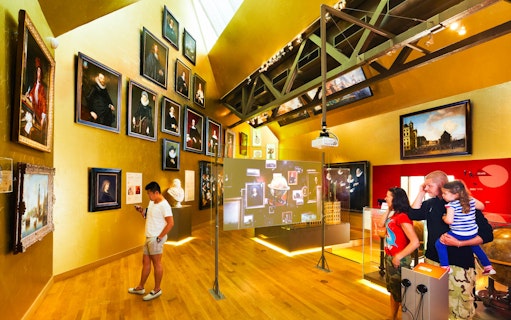 Amsterdam museum visitors viewing art exhibits and interactive displays.