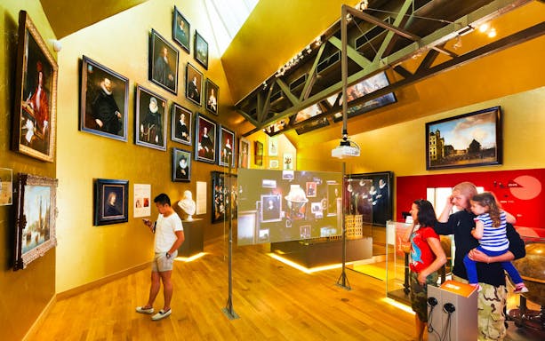 Amsterdam museum visitors viewing art exhibits and interactive displays.