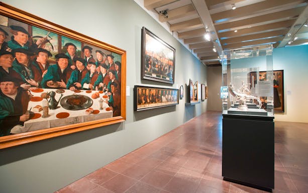 Amsterdam museum gallery with historical paintings and sculptures.