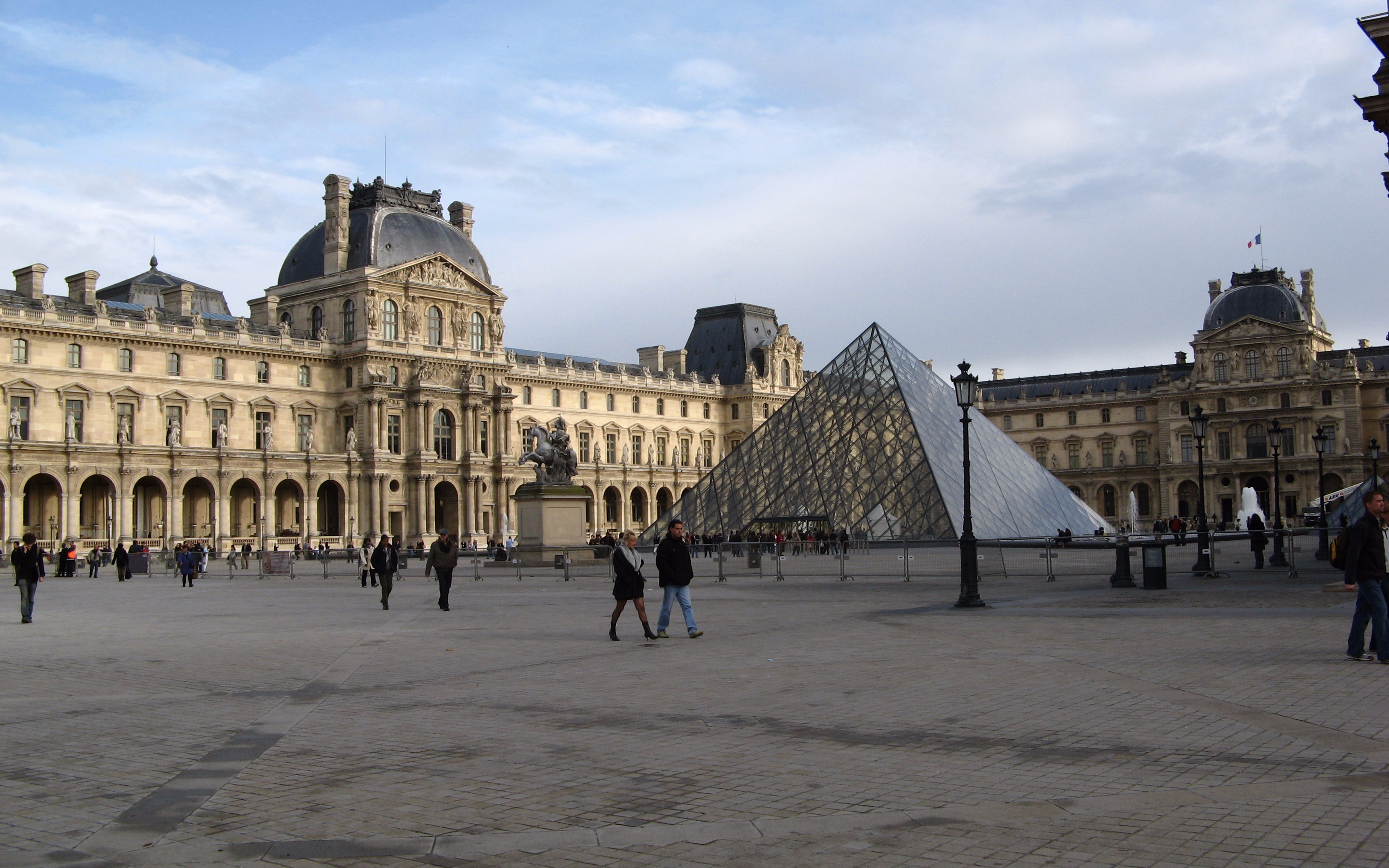 Louvre Museum courtyard with glass pyramid in Paris, France.