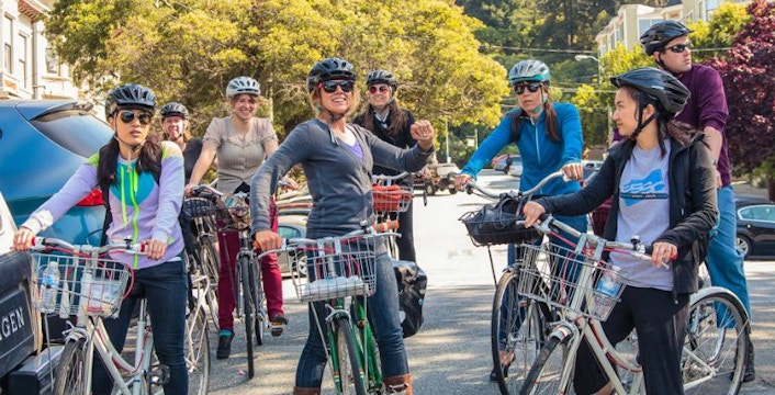 Cyclists riding past the Golden Gate Bridge on the SF Origins Bike Tour.