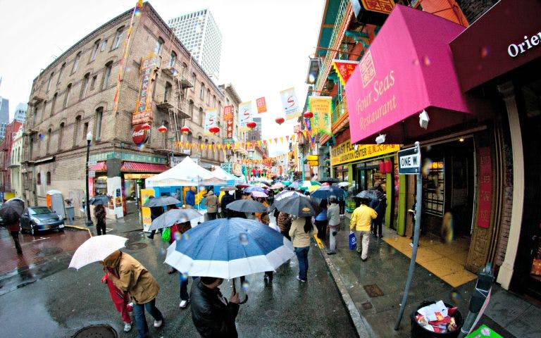 Chinatown street food vendors with tourists sampling traditional dishes on a walking food tour.