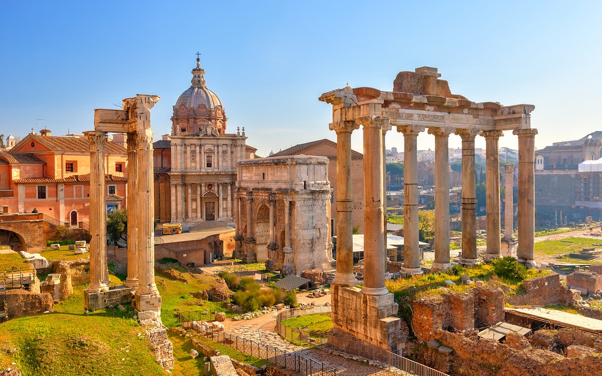 Roman Forum ruins with ancient columns and historic buildings in Rome, Italy.