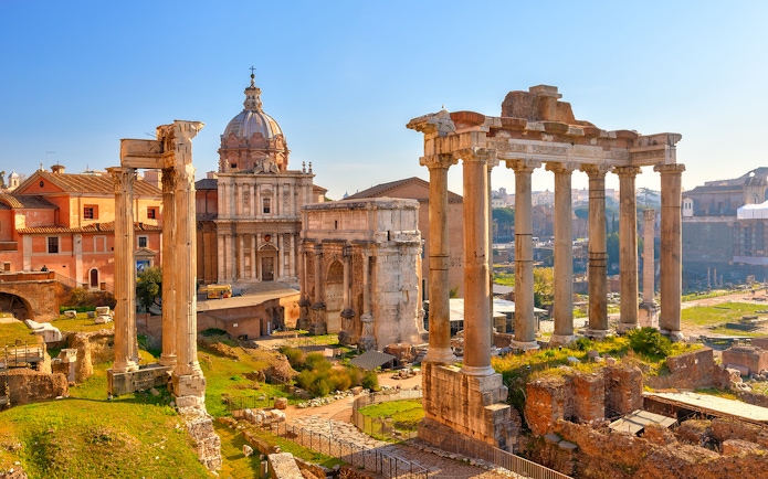 Roman Forum ruins with ancient columns and historic buildings in Rome, Italy.
