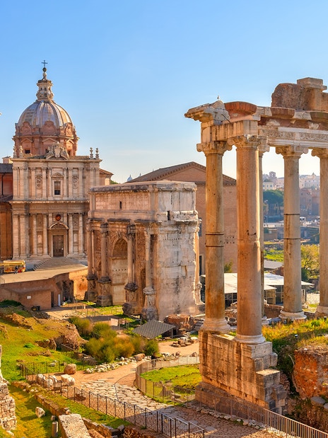 Roman Forum ruins with ancient columns and historic buildings in Rome, Italy.
