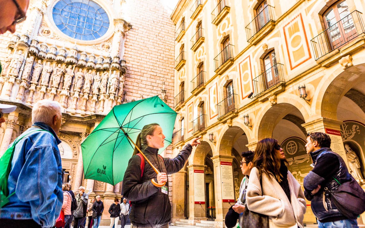 Tour group with guide at Montserrat Monastery, Spain, during self-guided tour.