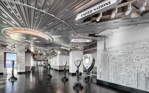 Empire State Building Observatory interior with viewing scopes and city mural.
