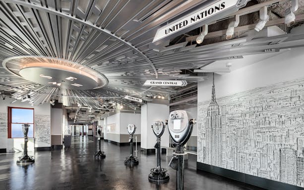 Empire State Building Observatory interior with viewing scopes and city mural.