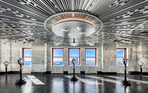 Empire State Building Observatory interior with city views through windows.