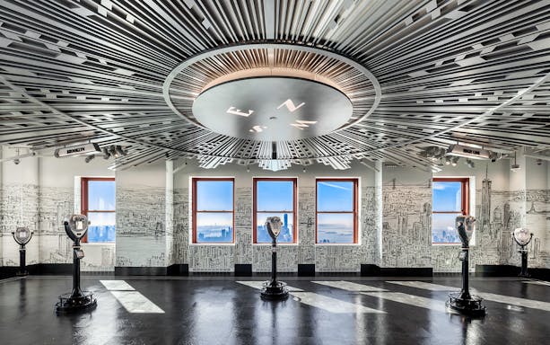 Empire State Building Observatory interior with city views through windows.