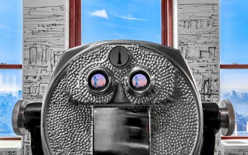 Coin-operated binoculars at Empire State Building Observatory with skyline view.