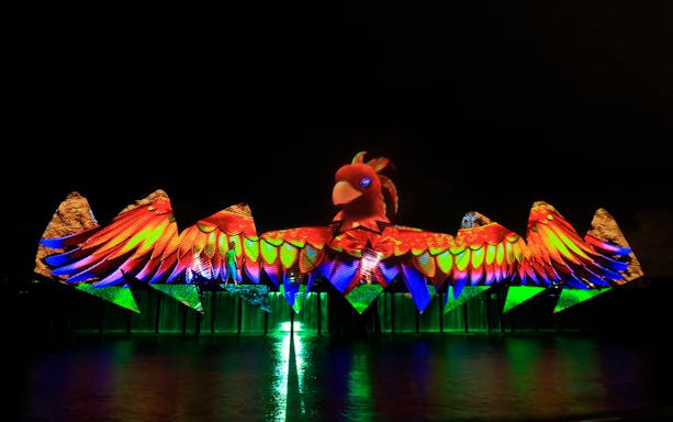 Colorful light show with bird projection at Wings of Time, Sentosa Island.