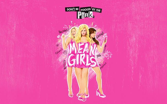 Three women in pink dresses with 'Mean Girls' text on a pink background.