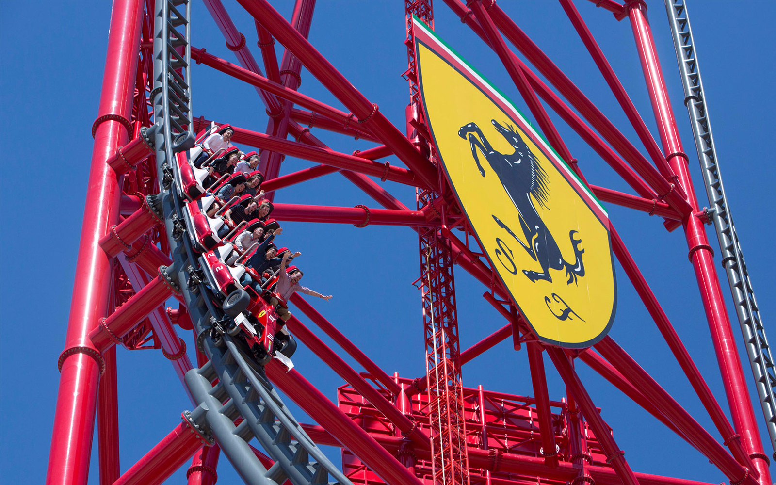 Roller coaster at Ferrari Land, PortAventura, with riders on a steep descent.
