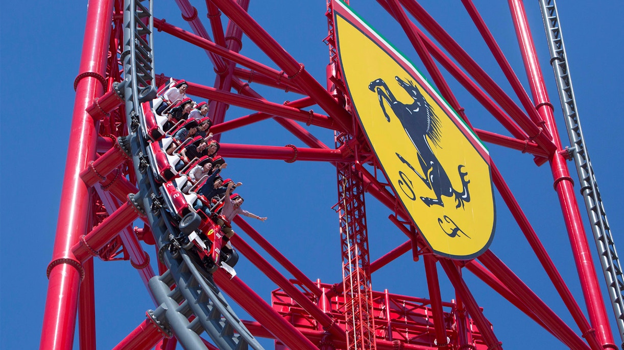Roller coaster at Ferrari Land, PortAventura, with riders on a steep descent.