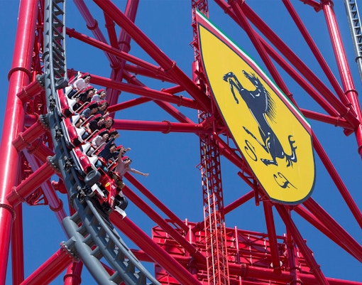 Roller coaster at Ferrari Land, PortAventura, with riders on a steep descent.