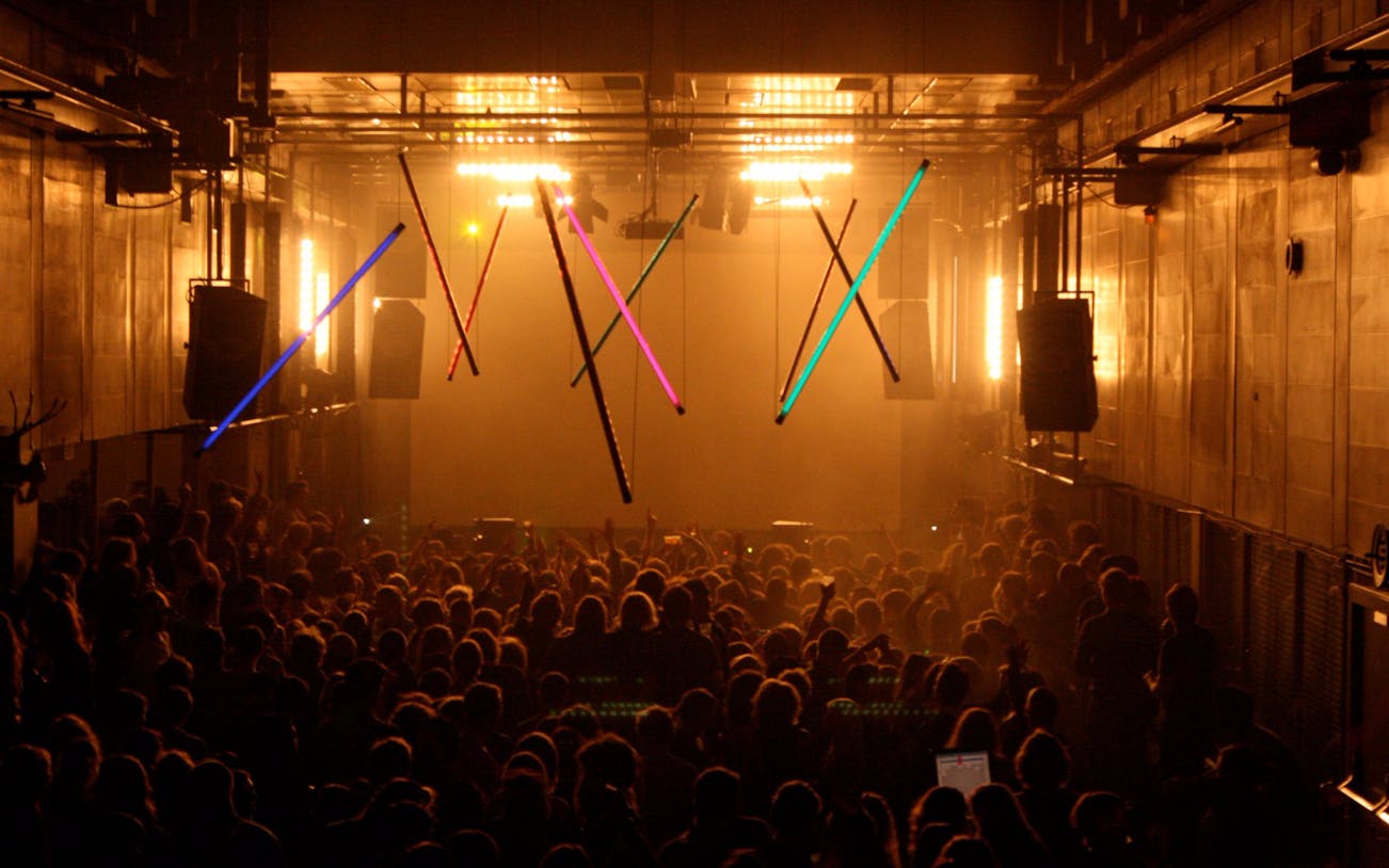 Crowd enjoying a vibrant nightclub in Amsterdam with colorful lights.