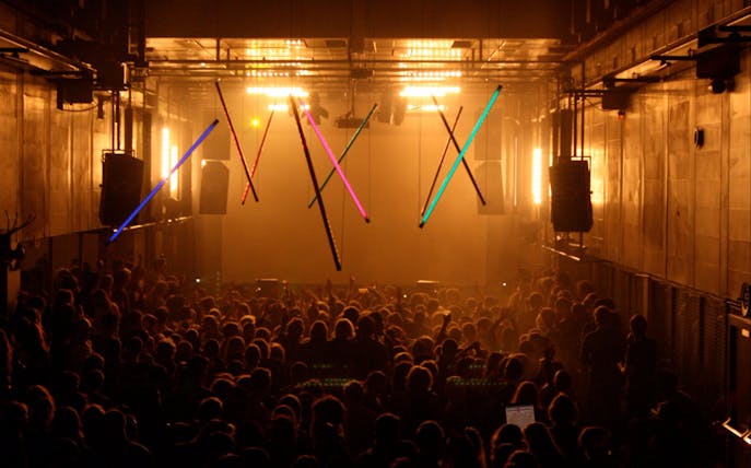 Crowd enjoying a vibrant nightclub in Amsterdam with colorful lights.