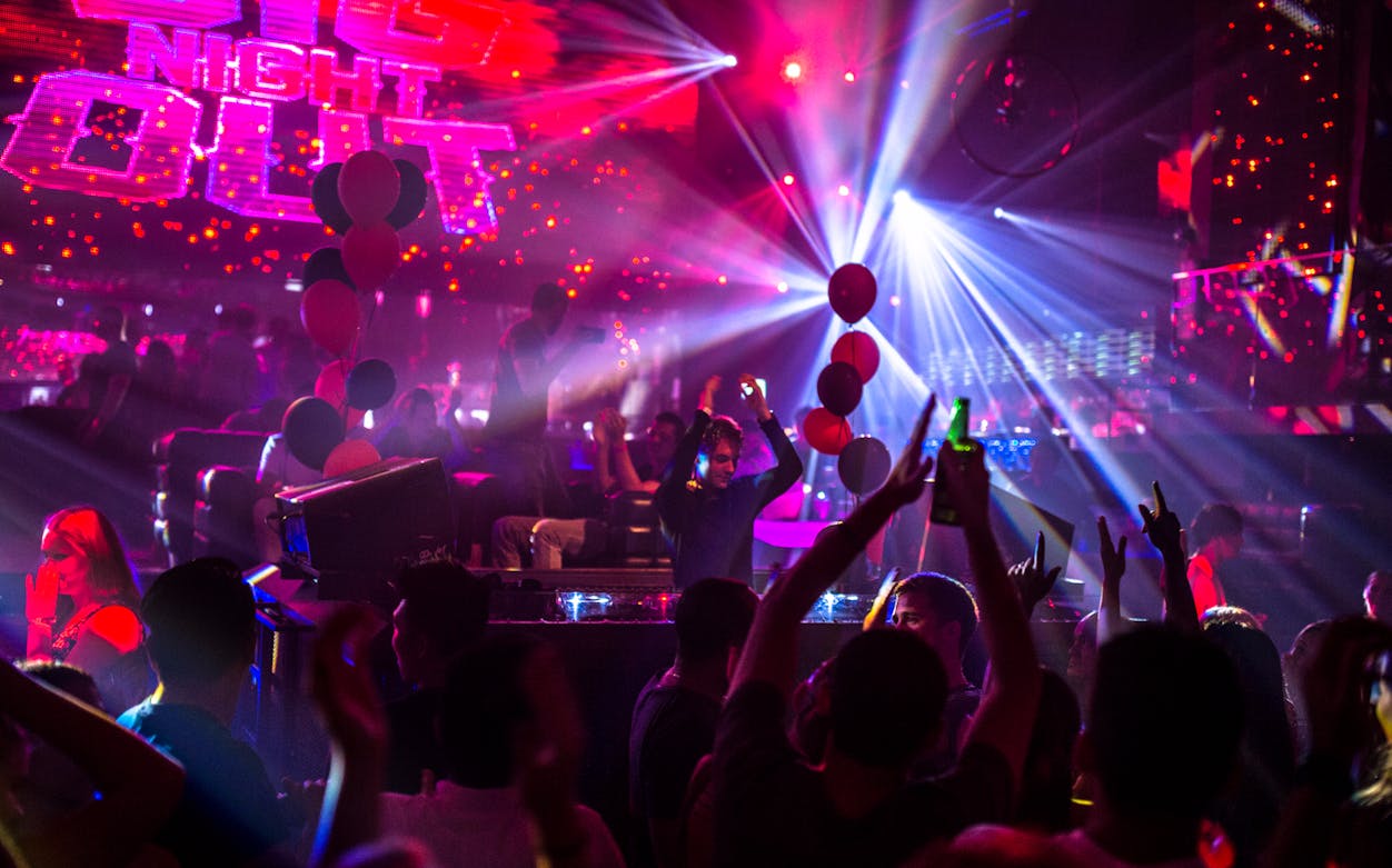 Amsterdam nightclub with vibrant lights and crowd enjoying music.