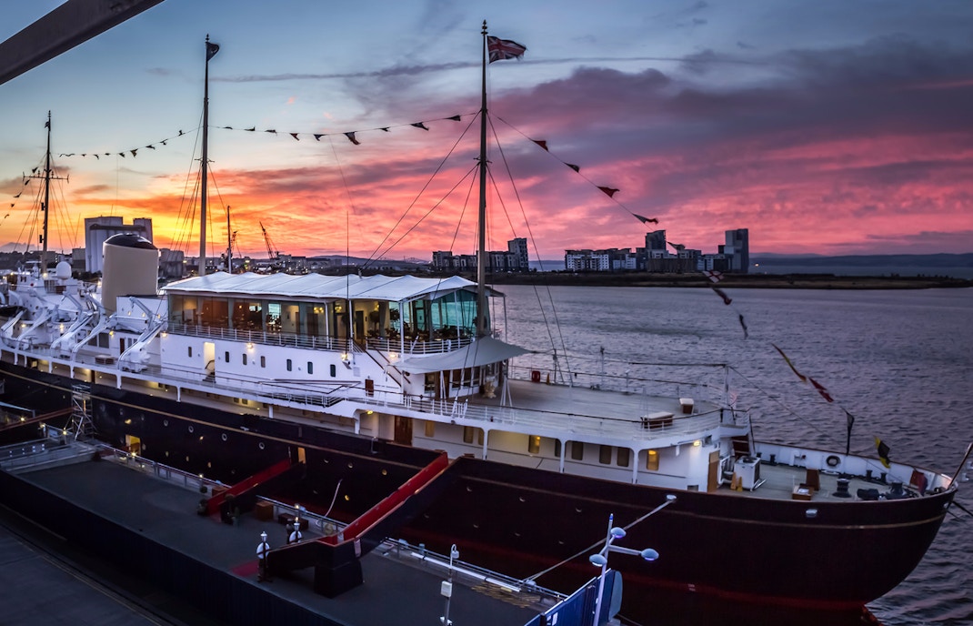 Royal Yacht Britannia docked in Edinburgh with visitors exploring the deck.