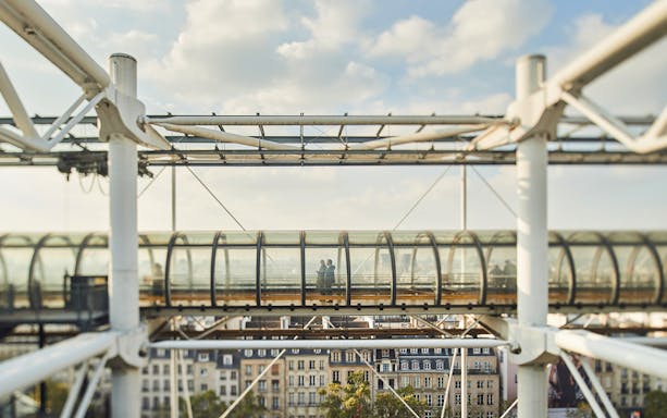 Centre Pompidou exterior view with people in glass walkway, Paris.