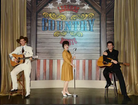 Wax figures of country music legends with guitars at Madame Tussauds Nashville.