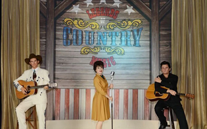 Wax figures of country music legends with guitars at Madame Tussauds Nashville.