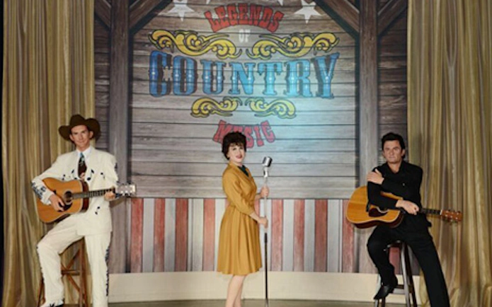 Wax figures of country music legends with guitars at Madame Tussauds Nashville.