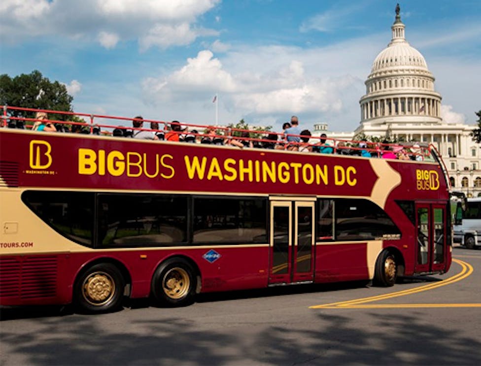 Hop on Hop off Big Bus Tour passing the U.S. Capitol in Washington DC.