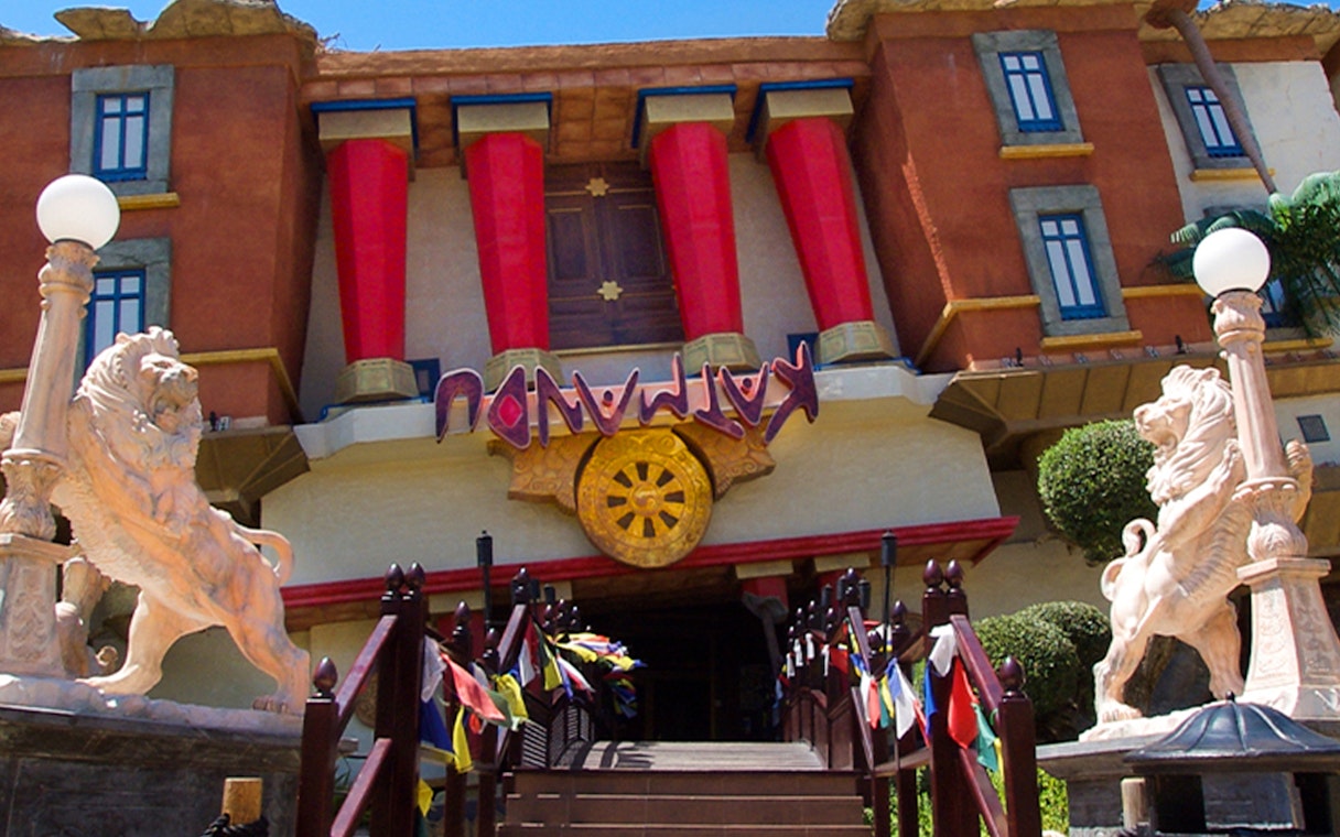 Katmandu Park entrance with lion statues and colorful flags, Mallorca.