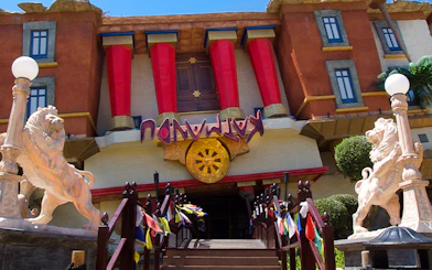 Katmandu Park entrance with lion statues and colorful flags, Mallorca.