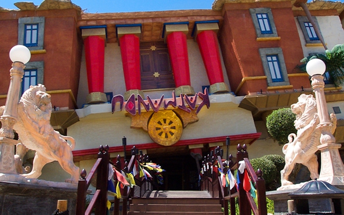 Katmandu Park entrance with lion statues and colorful flags, Mallorca.