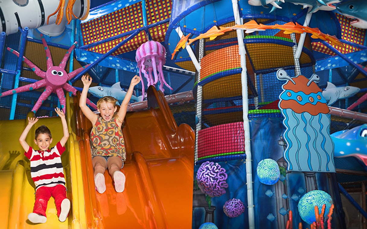 Children sliding in colorful play area at Katmandu Park.