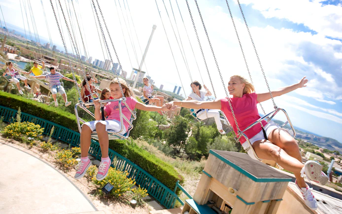 Visitors enjoying a swing ride at Terra Mitica theme park in Benidorm, Spain.