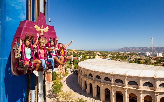 Visitors enjoying a drop tower ride at Terra Mitica with scenic views of Benidorm.